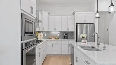 a kitchen with white cabinets and stainless steel appliances at Resorting To Happiness by AvantStay Close to the Beach w Pool Access in Inlet Beach