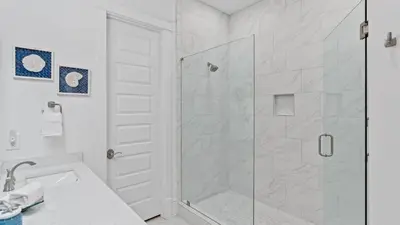a white bathroom with a shower and a sink at Resorting To Happiness by AvantStay Close to the Beach w Pool Access in Inlet Beach