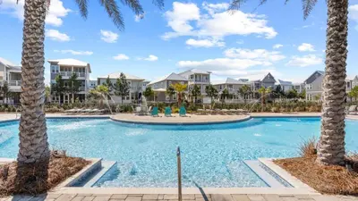 a pool with palm trees in front of condos at Resorting To Happiness by AvantStay Close to the Beach w Pool Access in Inlet Beach