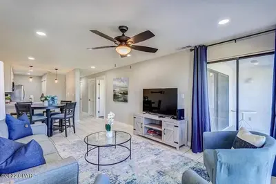 a living room with a ceiling fan and a table at Edgewater Beach Resort Dream Villa! One Bedroom in Panama City Beach