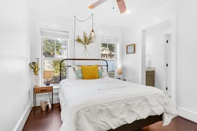 a white bedroom with a bed with yellow pillows at Narnia Grande Pointe Villa - Inlet Beach Pool & Clubhouse Access in Inlet Beach