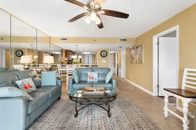 a living room with a couch and a table at Commodore 1205 with 2 beachfront masters in Panama City Beach
