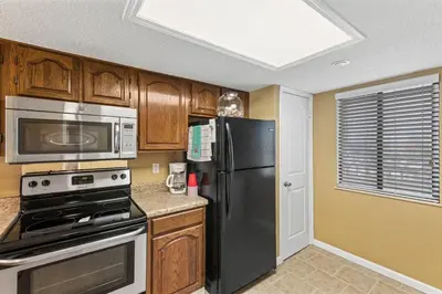 a kitchen with a black refrigerator and a microwave at Commodore 1205 with 2 beachfront masters in Panama City Beach