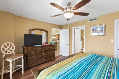 a bedroom with a bed and a flat screen tv at Commodore 1205 with 2 beachfront masters in Panama City Beach