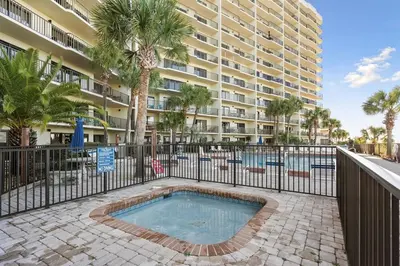 a swimming pool in front of a large building at Commodore 1205 with 2 beachfront masters in Panama City Beach