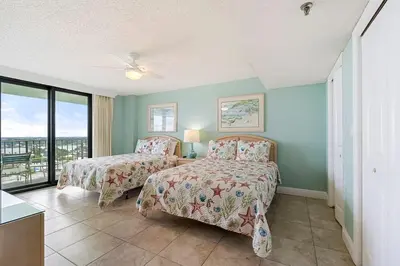 a bedroom with two beds and a balcony at Watercrest 1710 - Sunsets in Paradise - Sleeps 8 in Panama City Beach