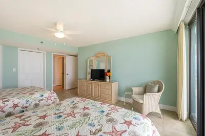 a bedroom with a bed and a chair and a mirror at Watercrest 1710 - Sunsets in Paradise - Sleeps 8 in Panama City Beach