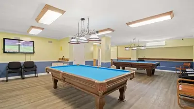 a billiard room with two pool tables and chairs at Regency Towers 1018 Beachfront unit in Panama City Beach