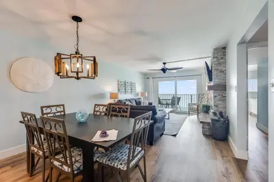 a dining room and living room with a table and chairs at Regency Towers 1018 Beachfront unit in Panama City Beach