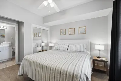 a bedroom with a bed with a striped bedspread at Seychelles 1406 Free Beach Chairs in Panama City Beach