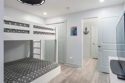a bedroom with a bunk bed and a desk at Edgewater Windward 508 - Newly Renovated Corner Condominium! in Panama City Beach