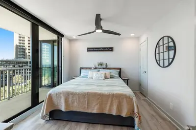 a bedroom with a bed and a large window at Edgewater Windward 508 - Newly Renovated Corner Condominium! in Panama City Beach