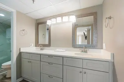 a bathroom with two sinks and a mirror at Watercrest 1403 - Stunning Ocean Overlook in Panama City Beach