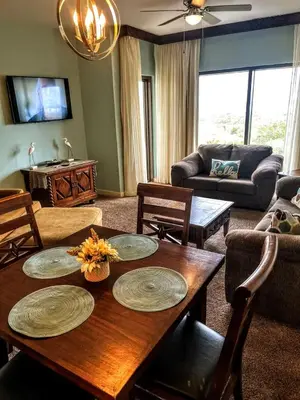 a living room with a wooden table and chairs at Origin Unit 911 in Panama City Beach