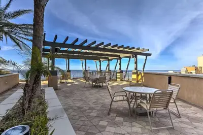a patio with tables and chairs and the ocean at Origin Unit 911 in Panama City Beach