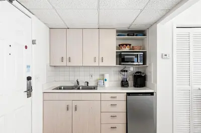 a kitchen with a sink and a microwave at Coastal Hideaway: Cozy Beachfront Studio – Sleeps 4 with Stunning Views! in Panama City Beach