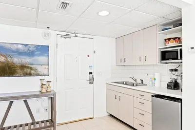 a kitchen with white cabinets and a sink at Coastal Hideaway: Cozy Beachfront Studio – Sleeps 4 with Stunning Views! in Panama City Beach