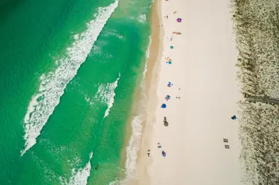 an overhead view of people on a beach with the ocean at Coastal Hideaway: Cozy Beachfront Studio – Sleeps 4 with Stunning Views! in Panama City Beach