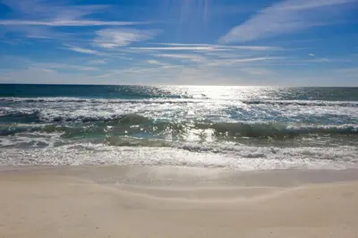 a beach with the ocean and the waves at Coastal Hideaway: Cozy Beachfront Studio – Sleeps 4 with Stunning Views! in Panama City Beach