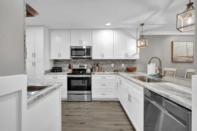 a kitchen with white cabinets and stainless steel appliances at Edgewater Beach Resort stay at Cozy Beach Getaway! in Panama City Beach