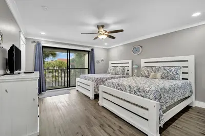 two beds in a bedroom with a balcony at Edgewater Beach Resort stay at Cozy Beach Getaway! in Panama City Beach