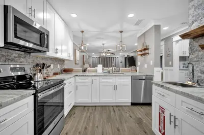 a white kitchen with white cabinets and appliances at Edgewater Beach Resort stay at Cozy Beach Getaway! in Panama City Beach