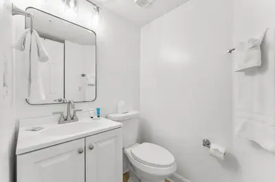 a bathroom with a toilet and a sink and a mirror at Serenity Found at A-521 in Panama City Beach