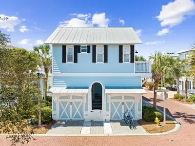 a blue house with a bike in front of it at Ocean Ayer Carriage House by 30A Escapes in Rosemary Beach