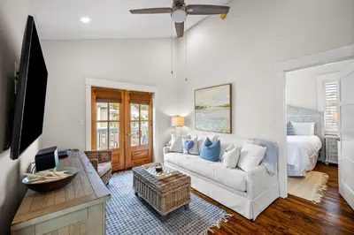 a living room with a white couch and a bed at Ocean Ayer Carriage House by 30A Escapes in Rosemary Beach