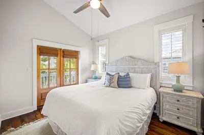 a white bedroom with a bed and a ceiling fan at Ocean Ayer Carriage House by 30A Escapes in Rosemary Beach