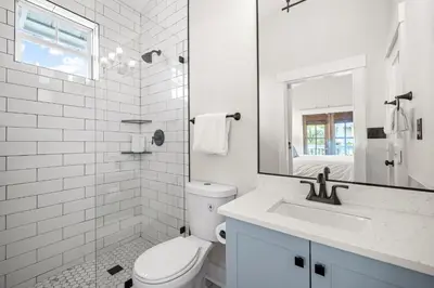 a white bathroom with a toilet and a sink at Ocean Ayer Carriage House by 30A Escapes in Rosemary Beach