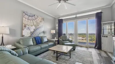 a living room with a couch and chairs and a large window at Penthouse at Laketown Wharf in PCB! 2132 in Panama City Beach