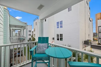 a balcony with two chairs and a table at Paradise found steps to beach in Panama City Beach