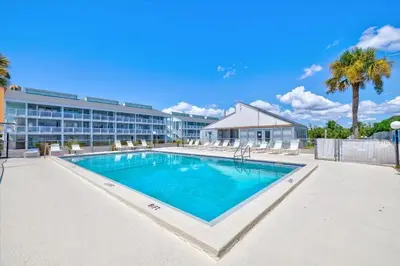 a large swimming pool in front of a hotel at Paradise found steps to beach in Panama City Beach