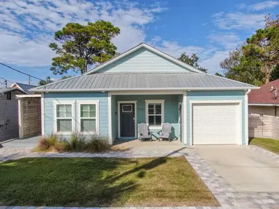 a blue house with two chairs in front of it at PCB 3 Bed 2 Bath house Chasing Sunsets in Panama City Beach
