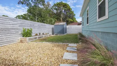 a yard next to a house with a fence at PCB 3 Bed 2 Bath house Chasing Sunsets in Panama City Beach