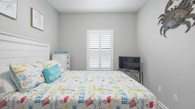 a bedroom with a bed and a fish on the wall at PCB 3 Bed 2 Bath house Chasing Sunsets in Panama City Beach