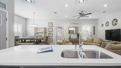 a kitchen with a sink and a living room at PCB 3 Bed 2 Bath house Chasing Sunsets in Panama City Beach