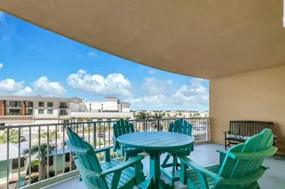 a patio with a table and chairs on a balcony at Calypso 3-309 - Gypsea's View in Panama City Beach