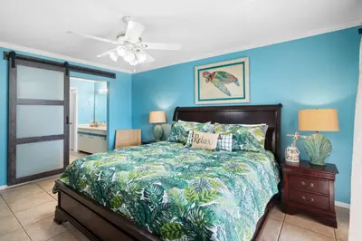 a blue bedroom with a bed and a ceiling fan at Edgewater Beach View Villas #3304 in Panama City Beach