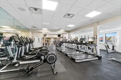 a gym with rows of treadmills and elliptical machines at Edgewater Beach View Villas #3304 in Panama City Beach