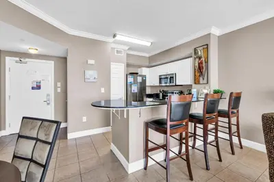 a kitchen and dining room with a bar and chairs at Tidewater 715 in Panama City Beach