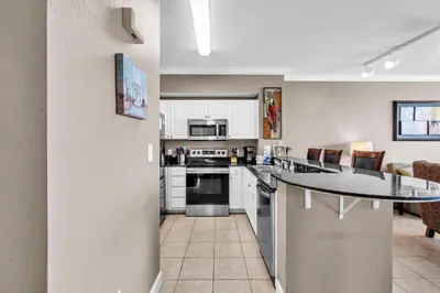 a kitchen with white cabinets and a counter top at Tidewater 715 in Panama City Beach
