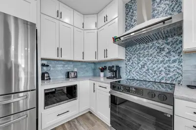 a kitchen with white cabinets and a stove top oven at Golden Seashell East in Panama City Beach