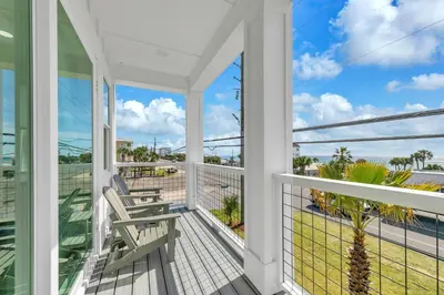 a balcony with two chairs and a view of the ocean at Golden Seashell East in Panama City Beach
