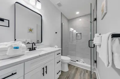 a white bathroom with a sink and a shower at Golden Seashell East in Panama City Beach