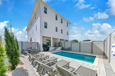 a house with a swimming pool and some chairs at Golden Seashell East in Panama City Beach