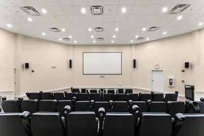 an empty lecture hall with a white screen and chairs at Tidewater 2903 in Panama City Beach