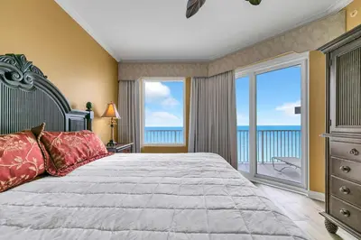 a bedroom with a large bed with a view of the ocean at Grandview East 1604 in Panama City Beach