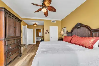 a bedroom with a large bed and a ceiling fan at Grandview East 1604 in Panama City Beach